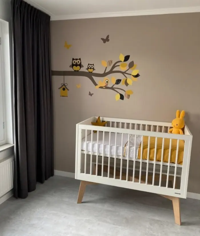 Okergele babykamer met een tak behangsticker